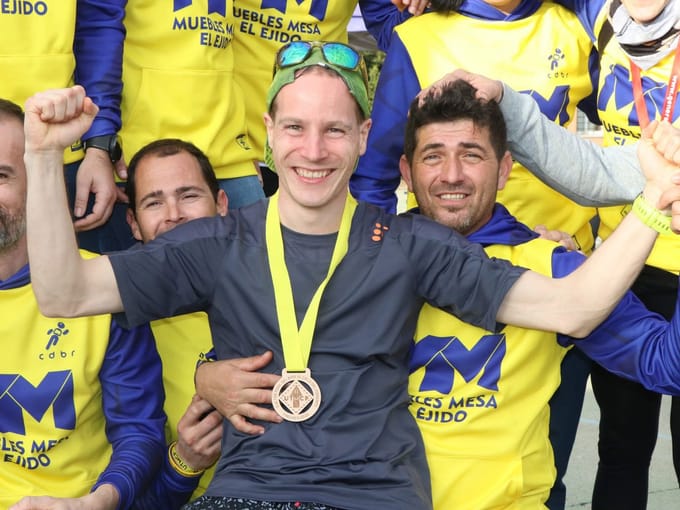 David på podiet i Spanien omgivet af jublende medløbere.