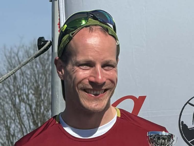 David tæt på med solbriller i panden og en lille pokal i hånden.