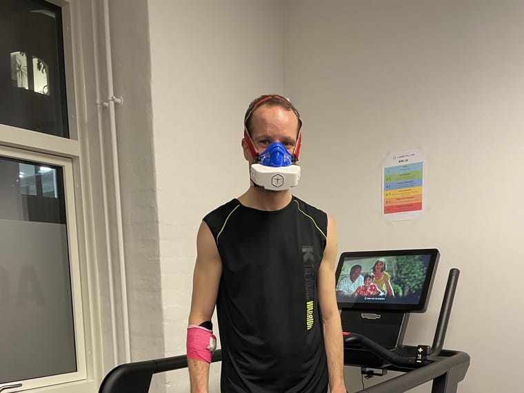 David løber på løbebånd med måleudstyr og maske for ansigtet.