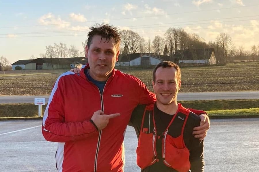 Robert i rød løbejakke og David med armene om hinanden på vejen efter en løbetur.