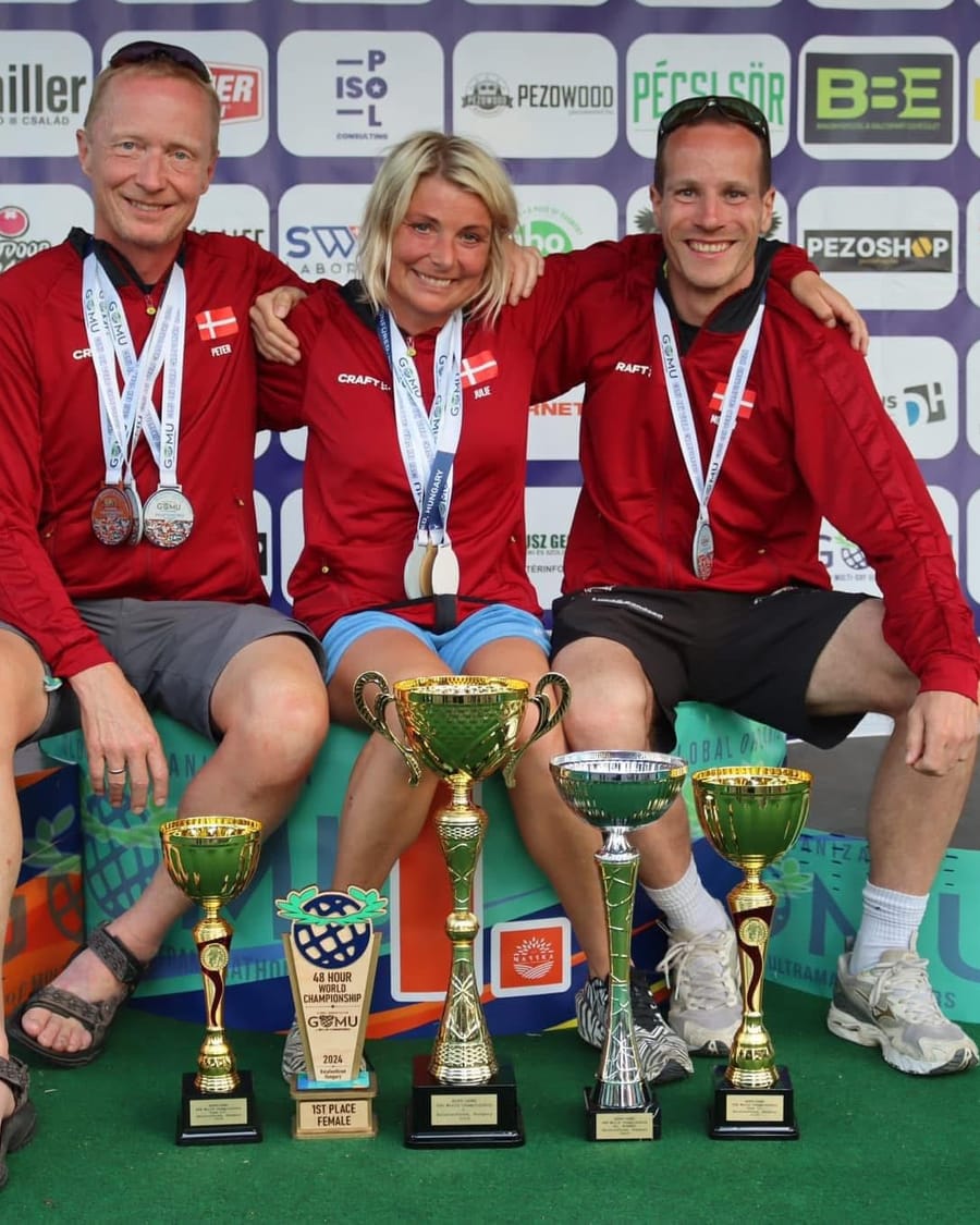 Tre ultraløbere fra Ultra4Charity på podiet med pokaler og medaljer.